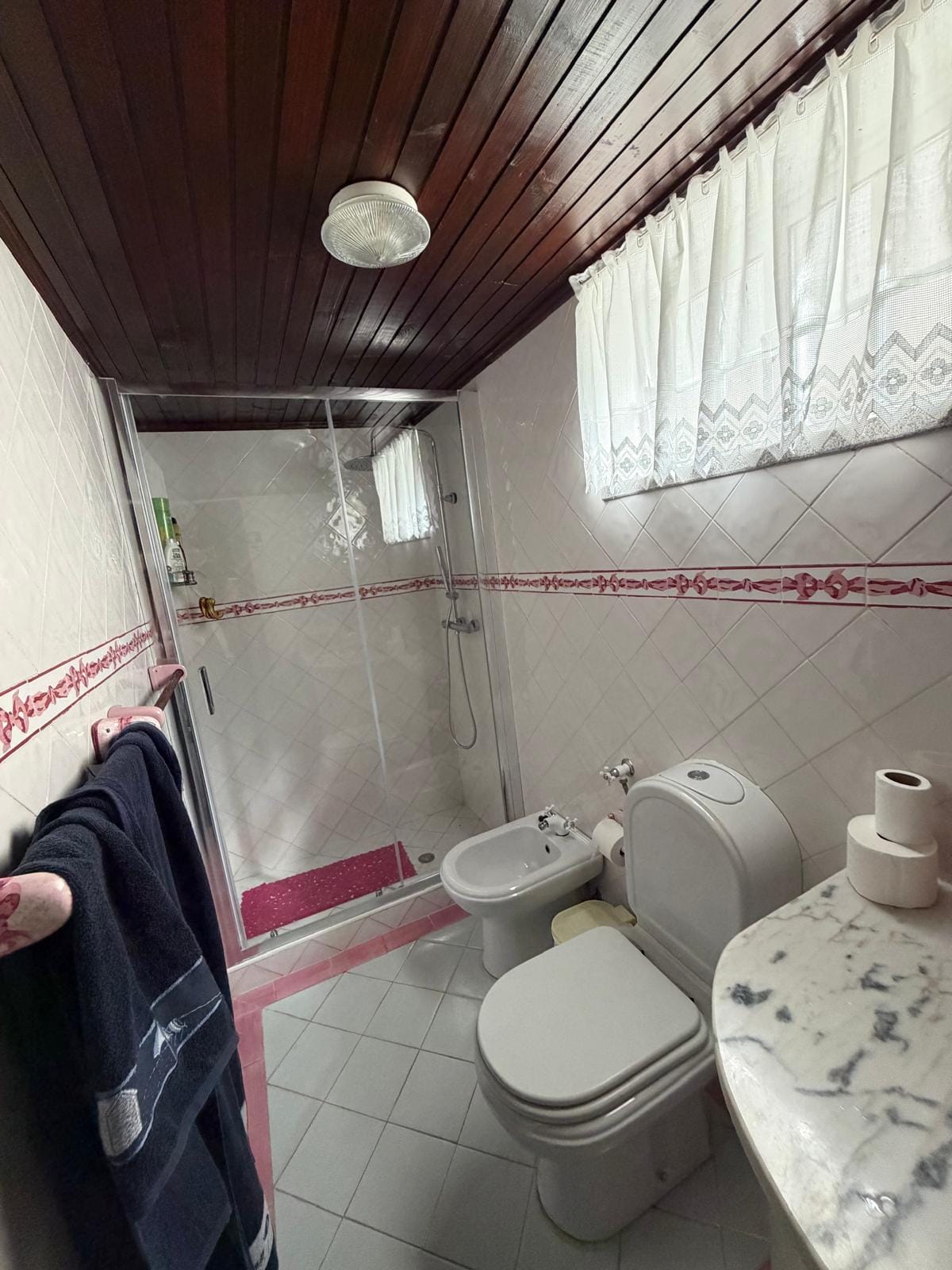 Casa de banho com base de duche, tetos de madeira e azulejo tradicional