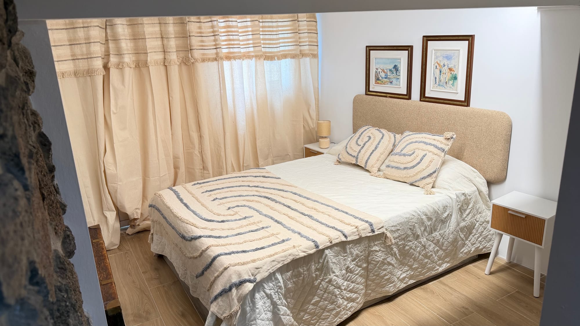 Quarto com cama de casal e roupa de cama neutra