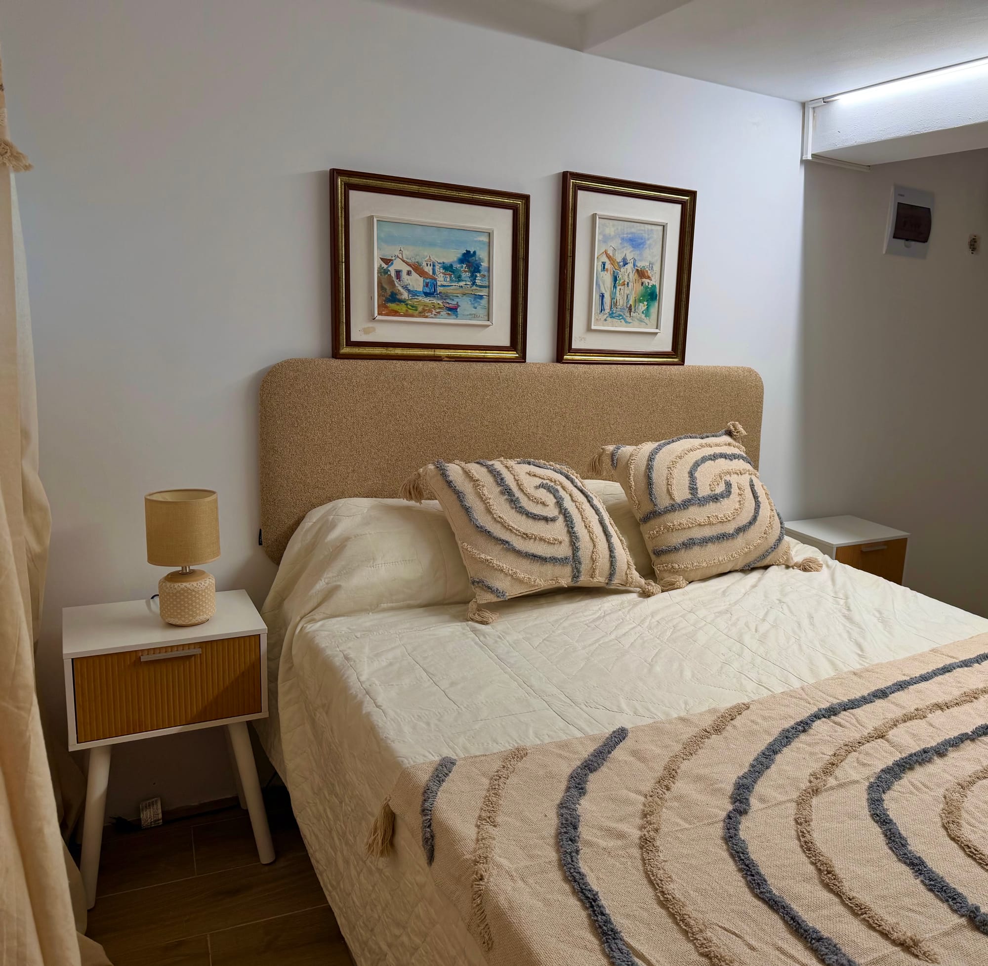 Quarto com cama de casal e quadros na parede
